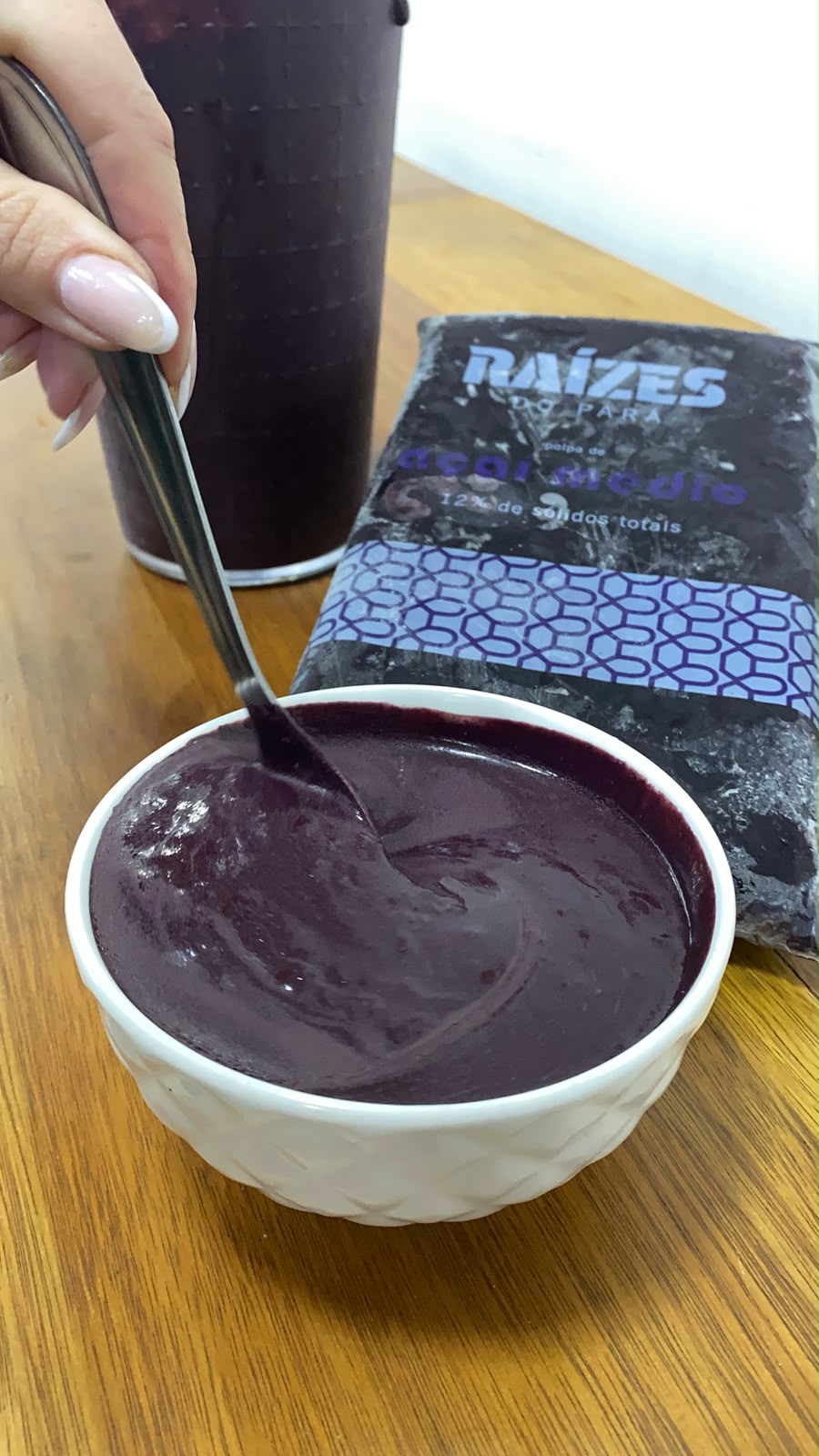 Tigela branca com açaí cremoso e uma colher